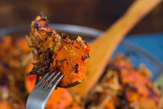 Trying vegetarian baked orange pumkin, mixed vegetables, herbs and cheese with folk