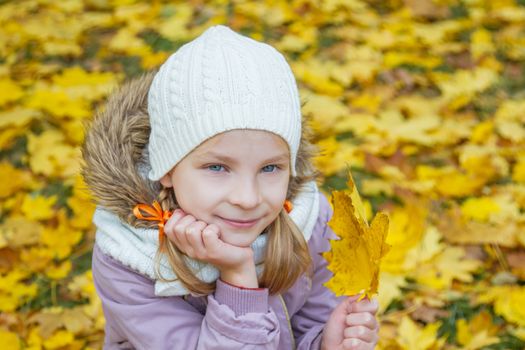 Cute girl close-up over autumn leaves