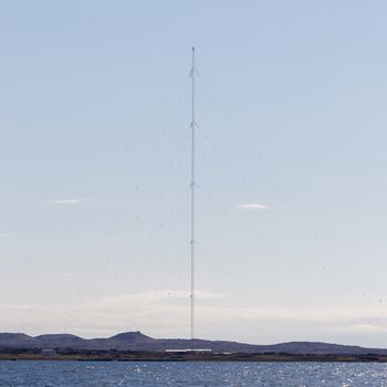 Tower communication sky. TV tower on a background of blue sky and clouds, Iceland