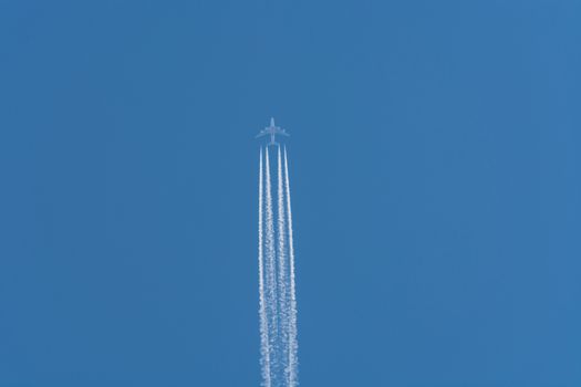 Aircraft flying at high altitude contrails against a dark blue sky.
