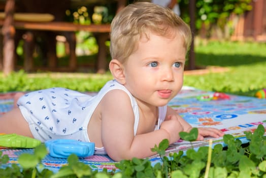 Beautiful baby boy eight month old crawling in the garden,close up.