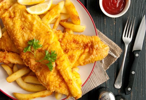 Close up of battered fish on a plate with chips