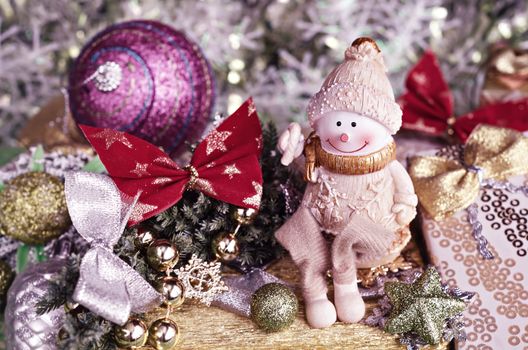 Christmas composition. Cheerful Snowman and Christmas tree decorations.Selective focus, toned pink.