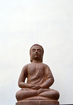Buddha sitting on a cabinet on white