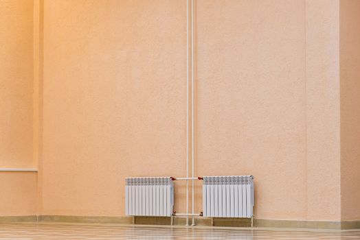 White new radiator on a pink wall