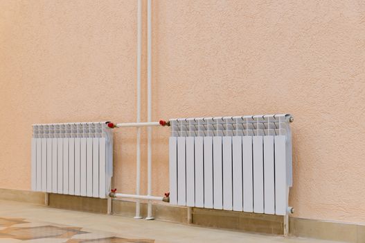 White new radiator on a pink wall