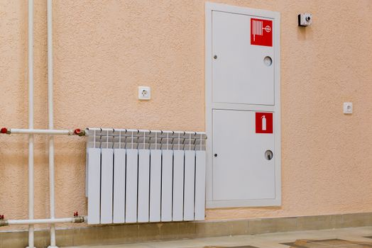 wall of the room with a sink, a fire hydrant and fire extinguisher