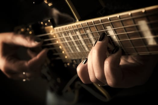 Close up view on a musican hand playing guitar