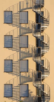 Symmetrical by repetition in warm sunlight of a spiral staircase