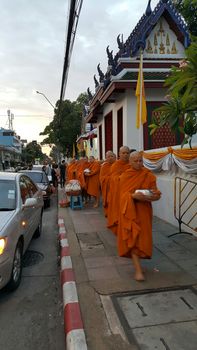 Bangkok, Thailand - 22 October 2016 : Line of monks walk to receive food offering from the Buddhist people.