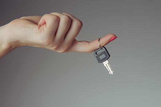 Keys from the car hold by female hand