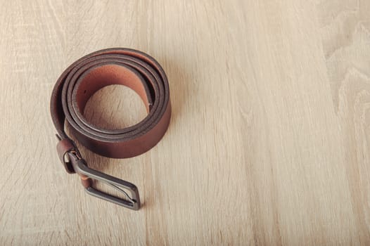 Leather belt on the wooden desk table