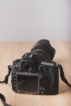 Digital photo camera on wooden desk table