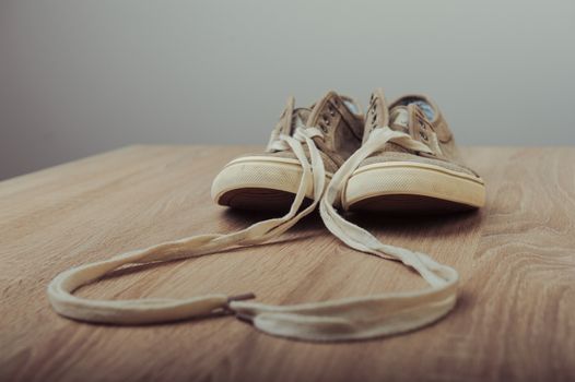 Blue lovely used sneakers on wooden desk