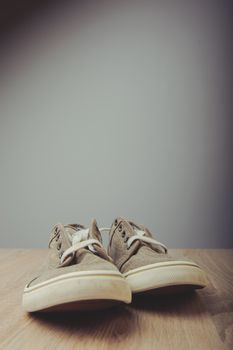 Blue lovely used sneakers on wooden desk