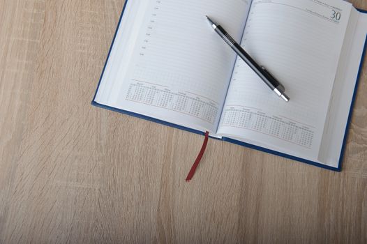 Notebook with pen on the wooden desk