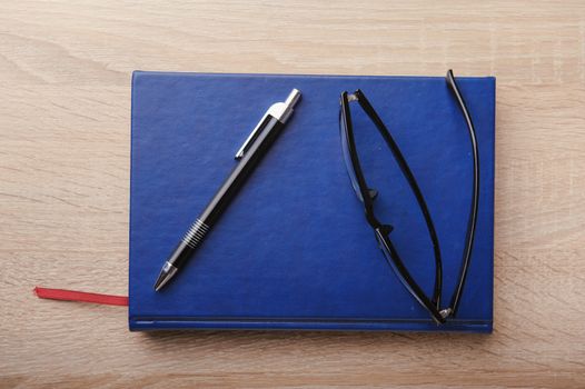 Notebook with pen on the wooden desk