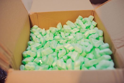 Large packaging box filled with many white styrofoam pellets