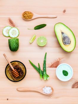 Homemade skin care and body scrub with natural ingredients avocado ,aloe vera ,lemon,cucumber and honey set up on wooden background.