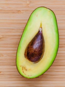 Fresh avocado on wooden background. Organic avocado healthy food concept. Avocado on Bamboo cutting board.The avocado is popular in vegetarian cuisine and weight control.