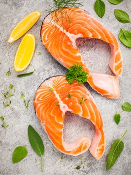 Fresh salmon fillet slice on dark stone background with herbs fennel ,sage ,rosemary thyme,parsley and lemon propose  for cooking . Healthy food concept.