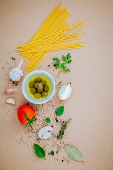 Italian food concept pasta with vegetables olive oil flavored with spices herb rosemary ,thyme,parsley and champignon mushroom set up with brown background.