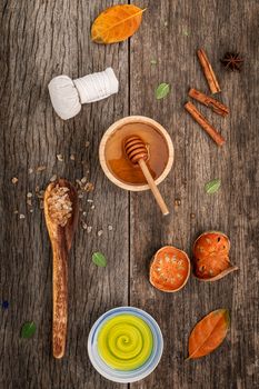 Composition of nature spa ingredients on the dark wooden table. Spa and wellness with dried indian bael ,herbal compress ball,turmeric,cinnamon powder ,cinnamon sticks ,aromatic oil and star anise.