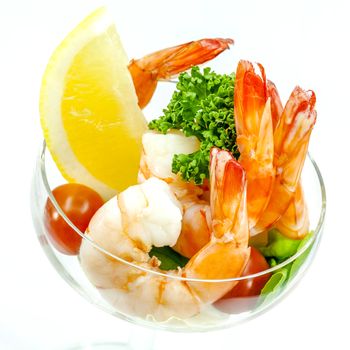 Fresh steamed shrimp in the glass isolate on white background. Boiled prawns with vegetable salad . Boiled prawns with lemon ,parsley and tomato isolated on white background.