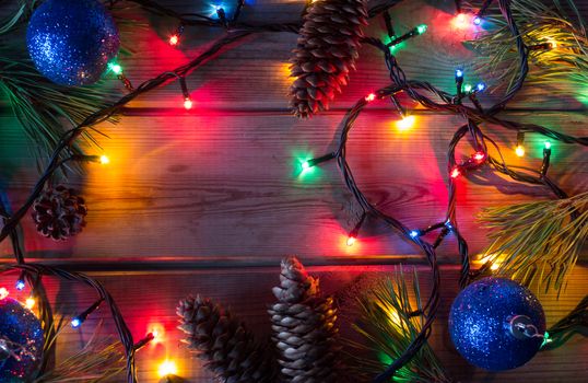 garland and Christmas tree branches on wooden table mock up