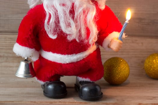 Santa Claus's hand with candle on wooden background