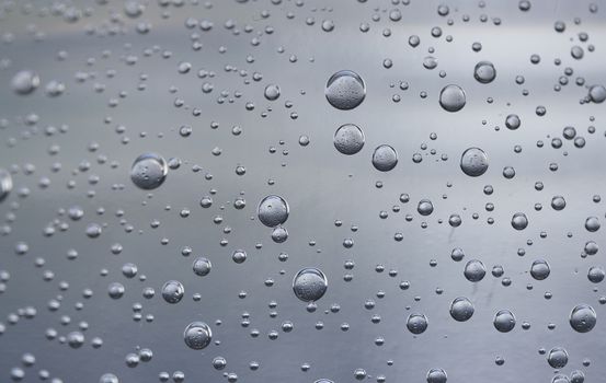 Water drops on blue transparent glass background