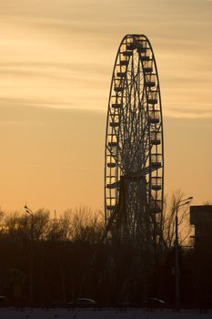 Silhouette of old ferris wheel at sunset in winter