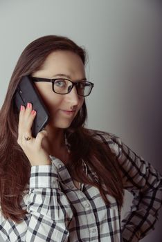 Happy brunette girl talking via smartphone at home