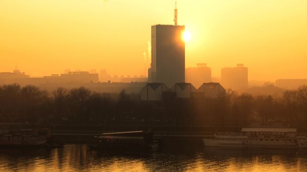 Sun going behind the building and view of the river Sava and urban scape of Belgrade city