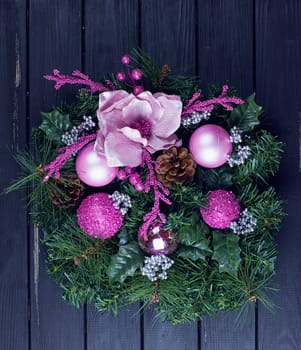 Christmas wreath on a rustic black wooden front door.