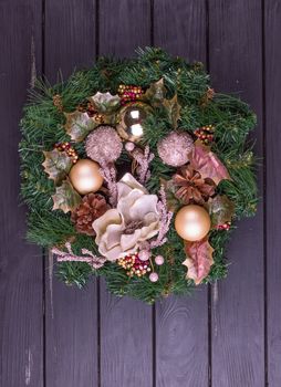Christmas wreath on a rustic wooden black front door.