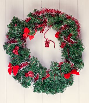 Christmas wreath on a rustic wooden white front door.