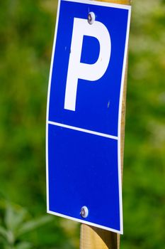 a blue parking sign with a big P on it on green background