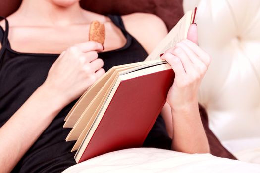 Woman reads book in a bed