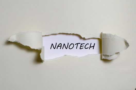 The word nanotech appearing behind torn paper