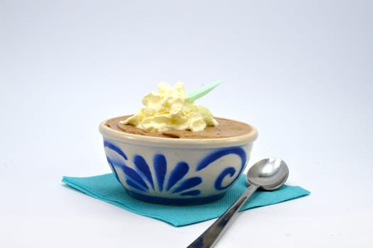 A dark chocolate mousse in a ramekin porcelain on a blue towel