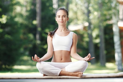 Pretty young woman doing yoga exercise in the park