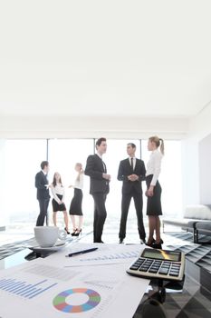 Group of business people and financial reports on table in office