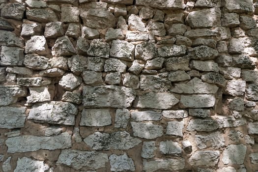 Part of the old wall made of grey stones and clay
