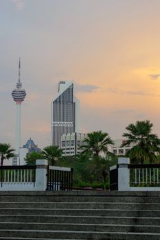Kuala Lumpur, Malaysia - January 16, 2016: a view of the KL Tower commucation tower between palms and plant
