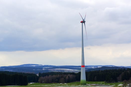 Wind power turbines generating electricity on a winter landscape