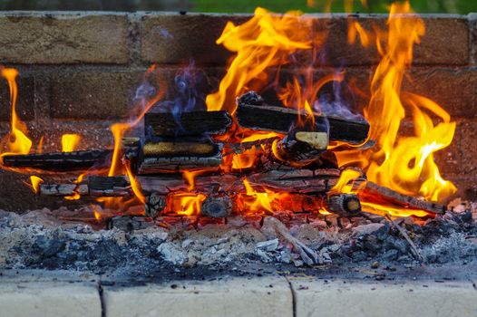 a flames on a Barbecue grill with lot of charcoal