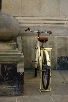 an old yellow bicycle. leather seat with shock absorbers and wheel