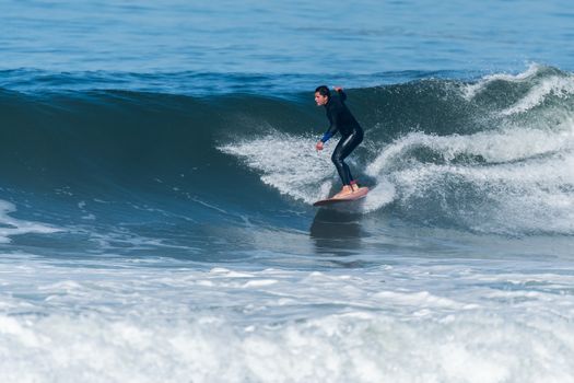 Surfer in action on the ocean waves on a sunny day.