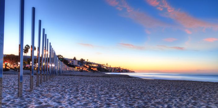 Sunrise over art titled One Forth Mile Arc by artist Phillip K. Smith  III stretches across Main Beach in Laguna Beach and consists of  200 stainless steel mirrored posts that appeared for only one weekend. Editorial use only.